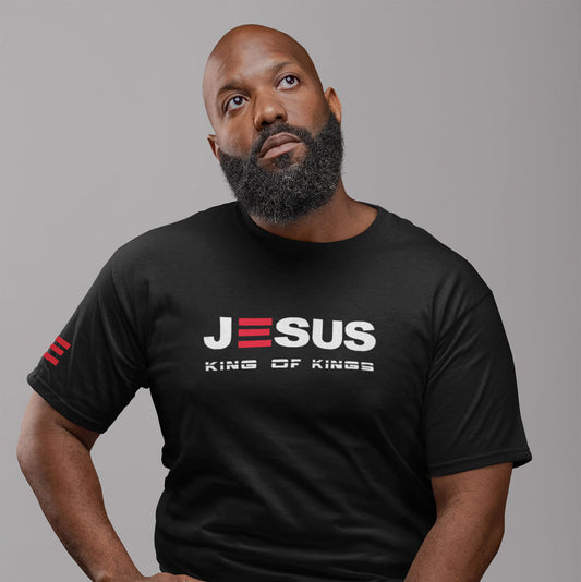 Man wearing a black t-shirt with 'Jesus King of Kings' text on a gray background
