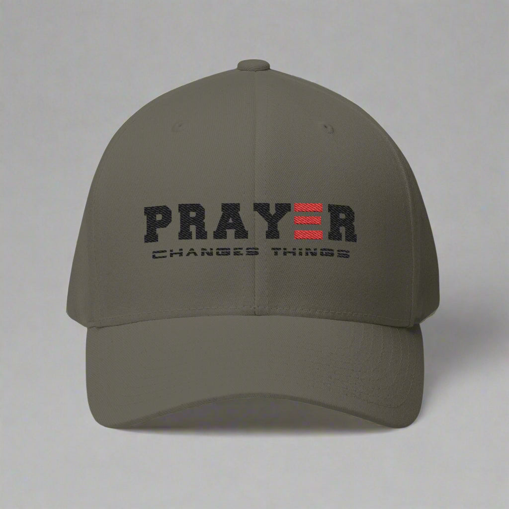 Olive cap with 'PRAYER CHANGES THINGS' text on a grey background