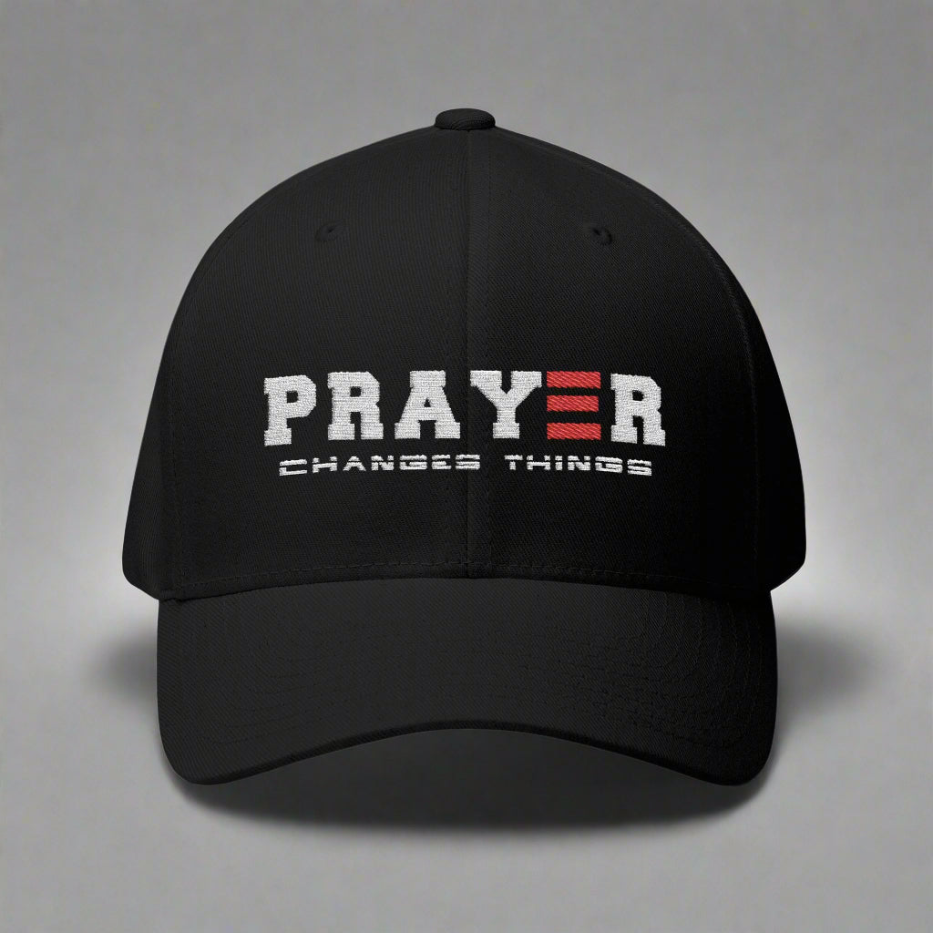 Black cap with 'PRAYER CHANGES THINGS' text on a gray background