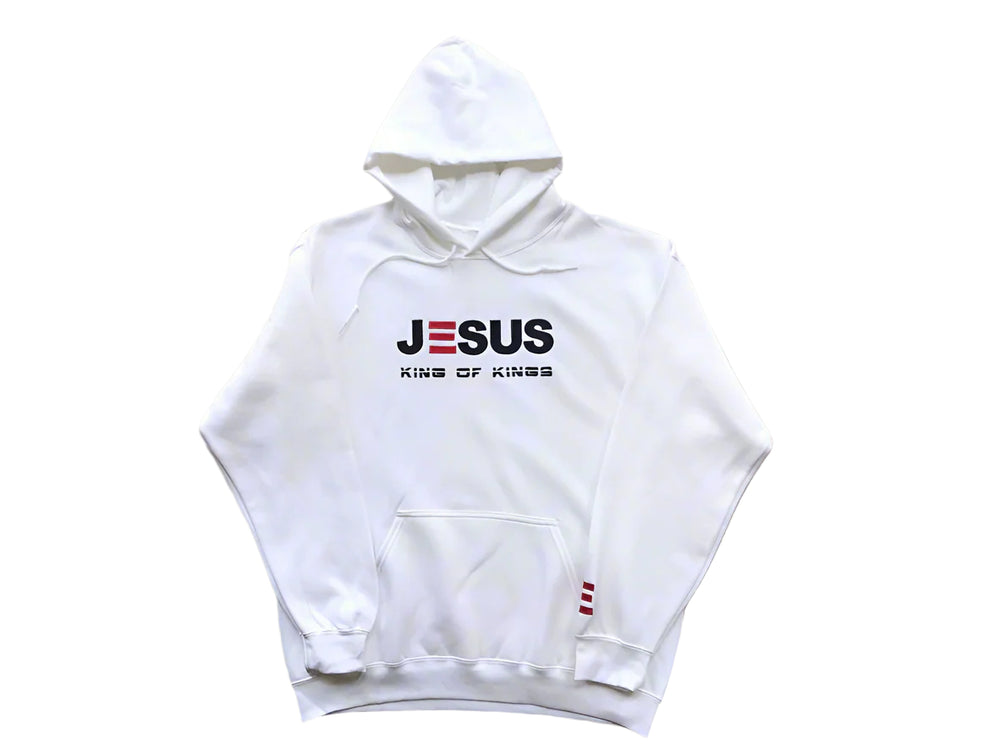 White hoodie with 'JESUS KING OF KINGS' text on a wooden surface
