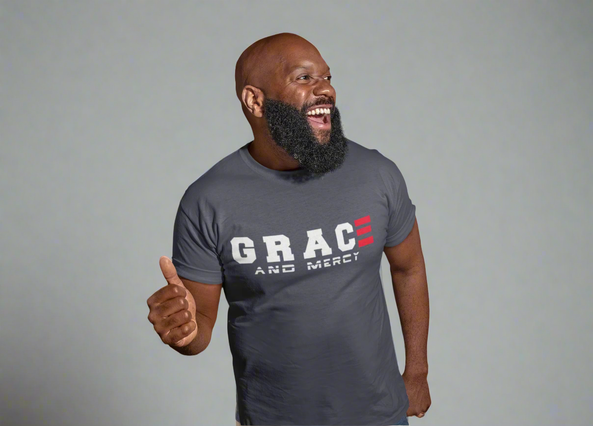 Man wearing a gray t-shirt with 'GRACE AND MERCY' text, giving a thumbs-up on a light gray background