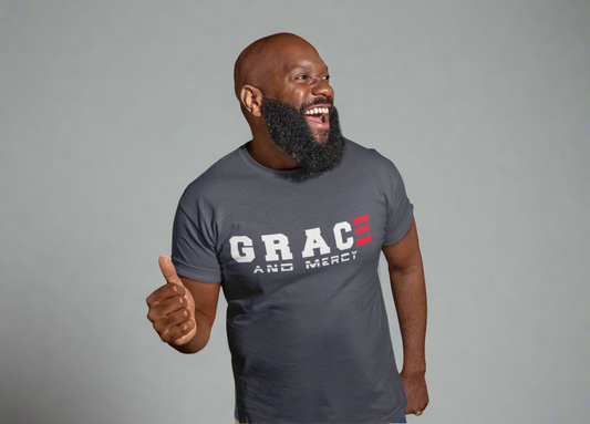 Man wearing a gray t-shirt with 'GRACE AND MERCY' text, giving a thumbs-up on a light gray background