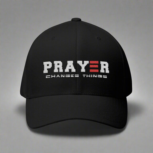 Black cap with 'PRAYER CHANGES THINGS' text on a gray background