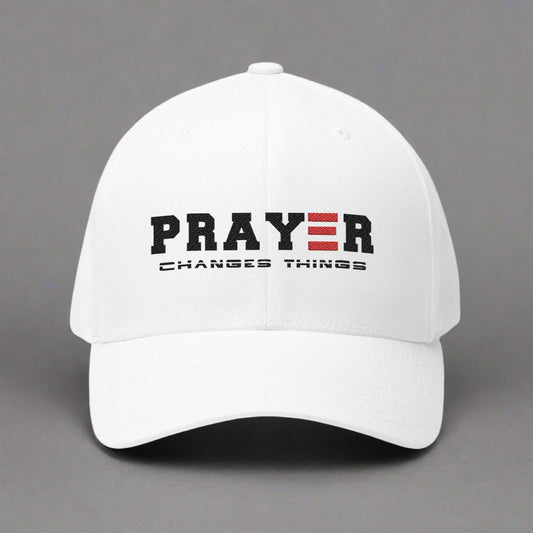 White cap with 'PRAYER CHANGES THINGS' text on a gray background